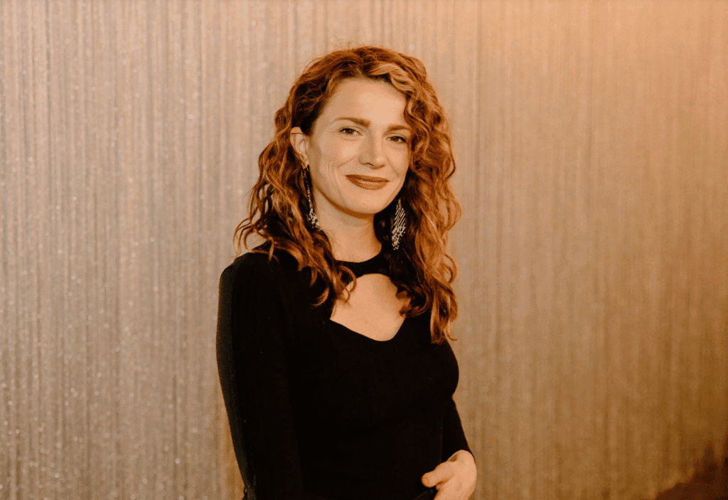 Elegant woman with curly red hair and black dress at Upper Cumberland Lifestyle event.