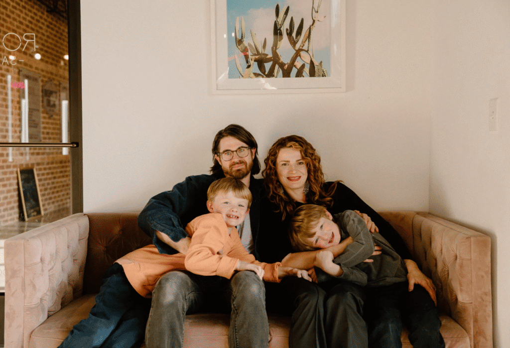 Family relaxing together on a sofa in a warm, inviting living room.