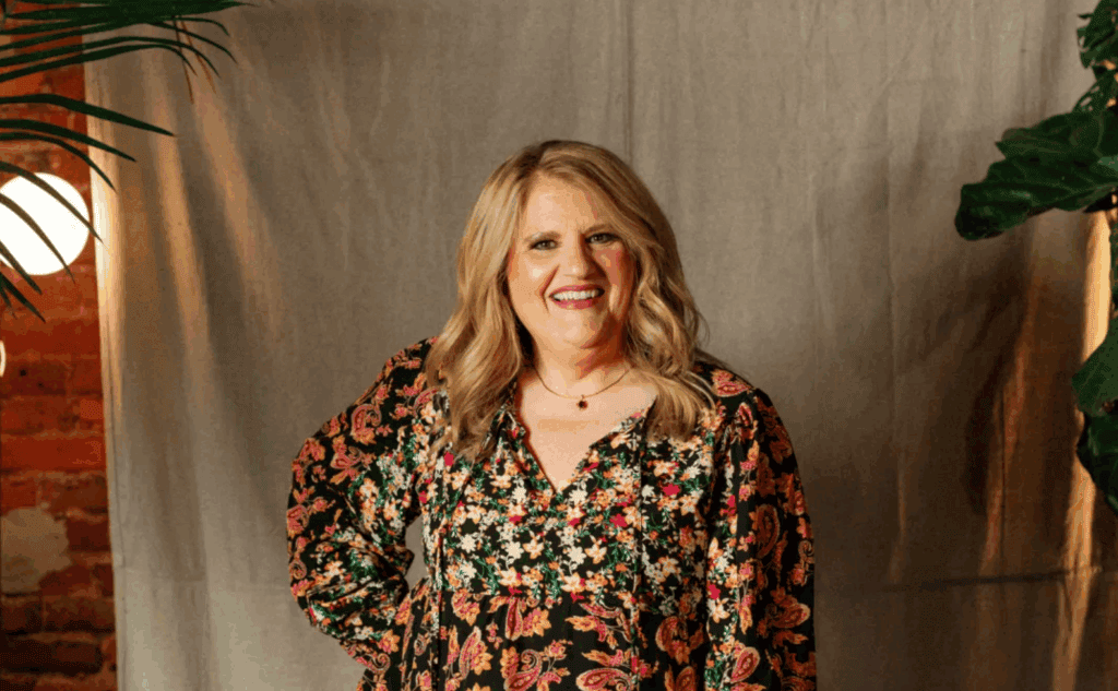 Woman smiling in floral dress at Upper Cumberland Lifestyle event.