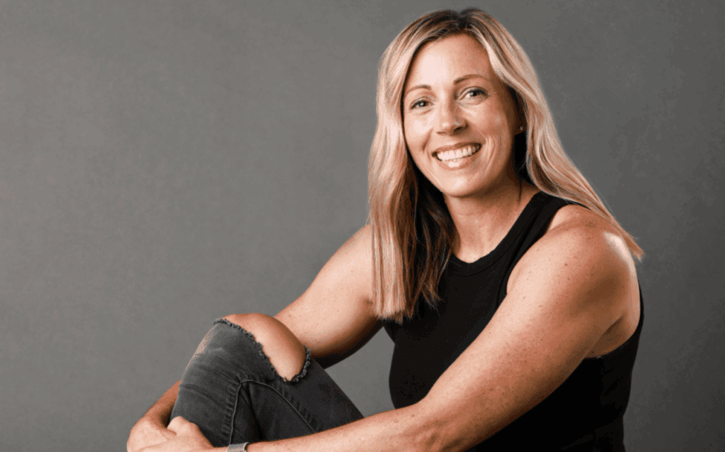Woman smiling in casual black top and ripped jeans, representing vibrant lifestyle in Upper Cumberla.
