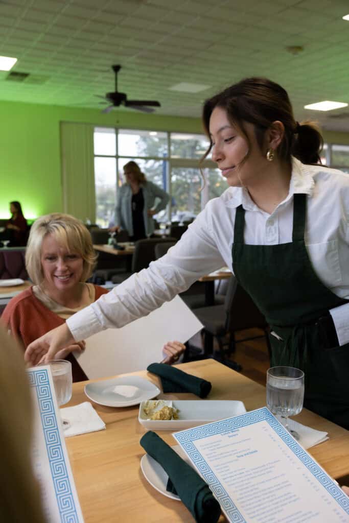 Friendly waitress serving food at Upper Cumberland restaurant.
