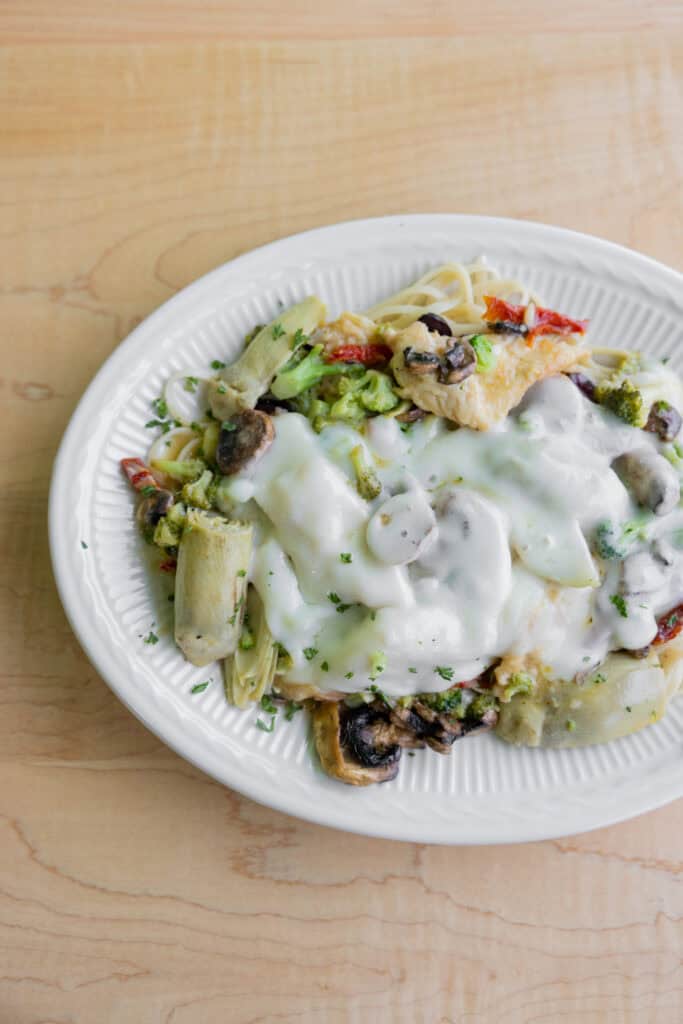 Delicious creamy vegetable pasta topped with mushrooms, cheese, and fresh herbs, perfect for a heart.