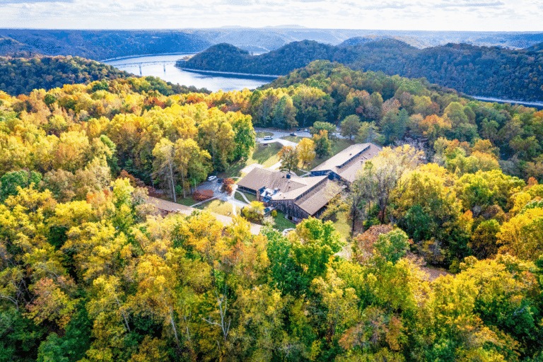 Scenic view of a forested area with a river and a building in the Upper Cumberland region.